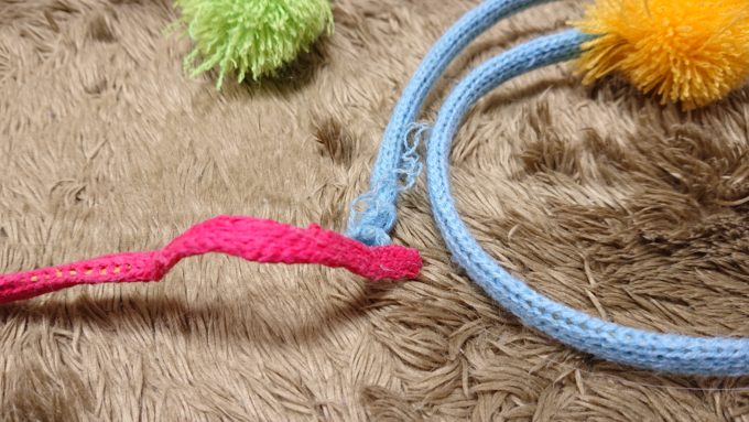 噛まれ過ぎて糸がほどけてしまったおもちゃの紐。誤食の危険性がある。